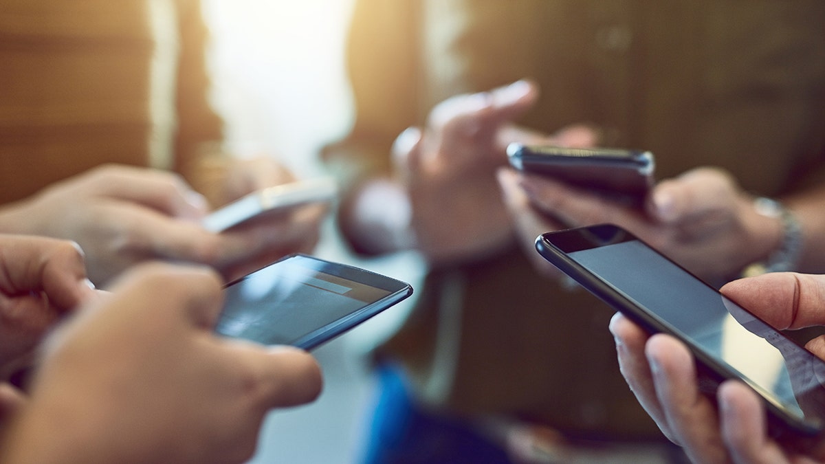 A group of colleagues use their smart phones in harmony